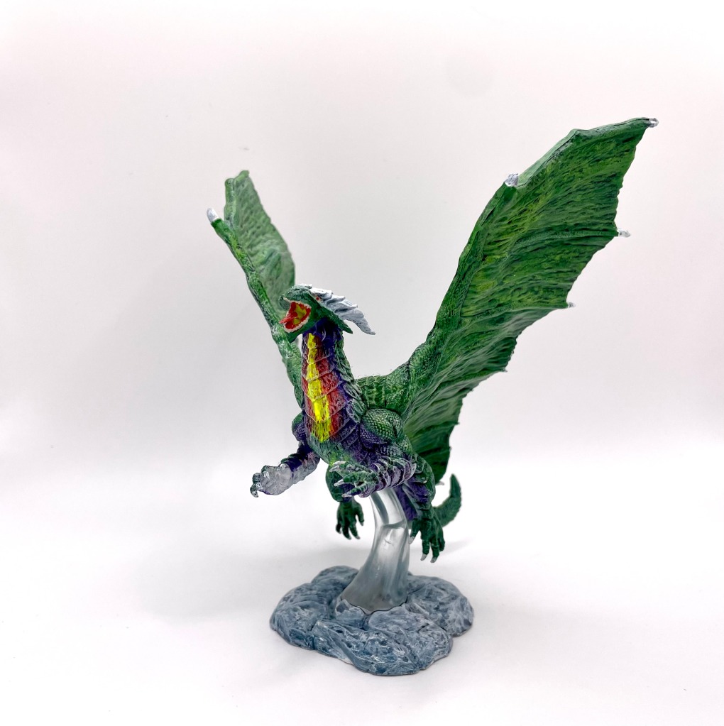 A green dragon in flight. The colors on its neck make it seem like it is about to spew fire. 